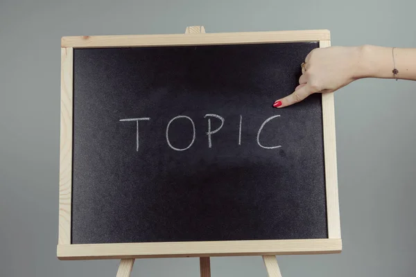 Topic written in white chalk on a black chalkboard — Stock Photo, Image