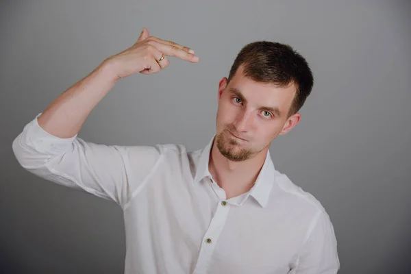 Young man pointing finger gun gesture to head — Stock Photo, Image