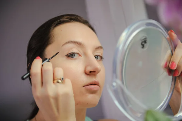 Mujer está haciendo maquillaje — Foto de Stock