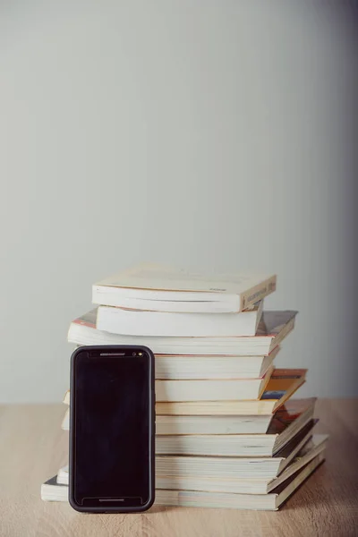 Старые старинные книги, смартфон — стоковое фото