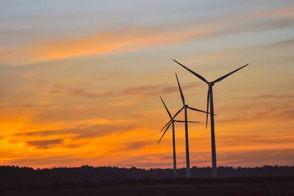 Silhuetten av vindkraftverk på sunset — Stockfoto