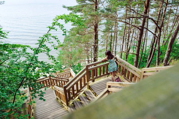 Girl sitting on the wooden stairs in park and smiling — Stock Photo, Image