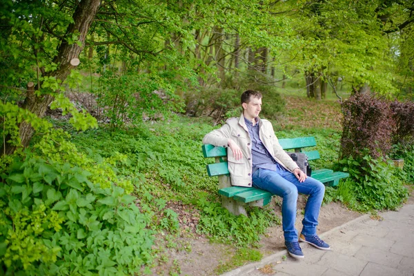 Мужчина сидит на скамейке в парке — стоковое фото