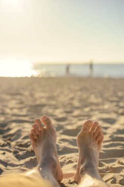 Ayak closeup kumsalda güneş güneşli yaz günü zevk şezlong üzerinde.