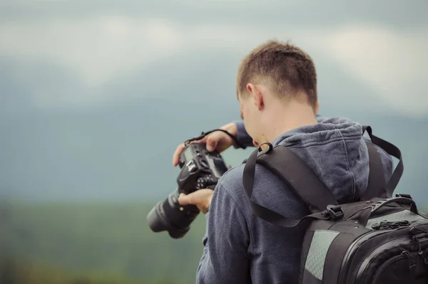 男のカメラマンは山で写真を撮る — ストック写真