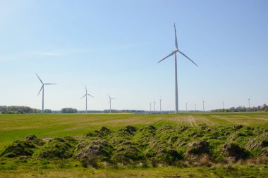 Parlak mavi gökyüzü hareket ediyor ve rüzgar türbini