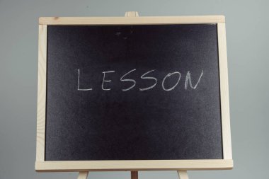 Beyaz tebeşir siyah bir kara tahta yazılı ders. gri arka planı