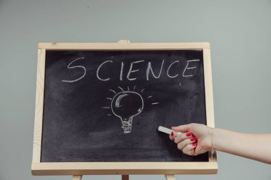 Bir öğretmen yazma bilim, gri arka plan kimya öğeleri koyu kara tahta el ile çizim