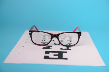 Snellen test çizelgesinde duran gözlüklerin görüntüsünü kapat