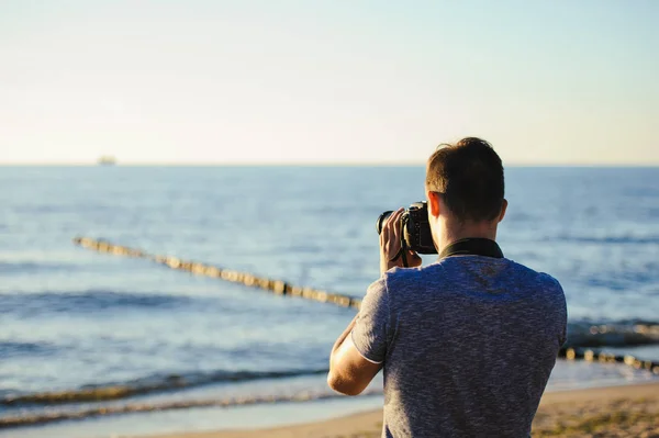 在海滩上的年轻摄影师的轮廓 夏季时间 — 图库照片