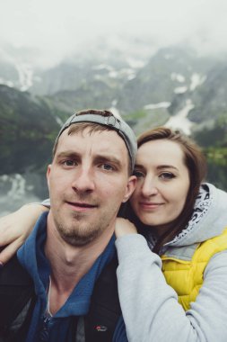 Happpy çift alarak selfie Gölü arka planda dağlar ile