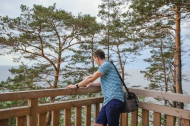 park ve gülümseyen ahşap merdivenlerde oturan adam