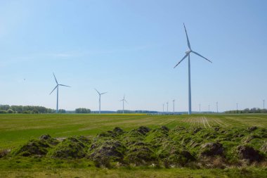 Parlak mavi gökyüzü hareket ediyor ve rüzgar türbini