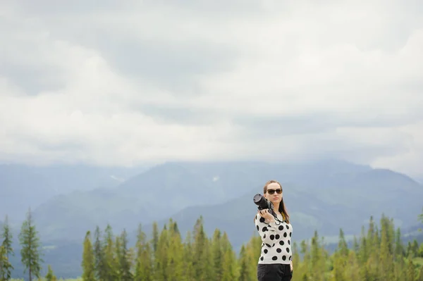Kobieta fotograf wykonuje zdjęcia w góry — Zdjęcie stockowe