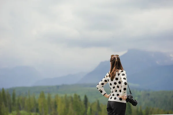 Mujer fotógrafa toma fotos en la montaña —  Fotos de Stock