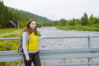 Kadın turist dağ nehir kenarında duran