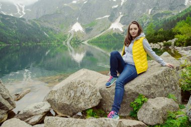 Kadın gölde ve dağlarda dinleniyor güneşli manzara