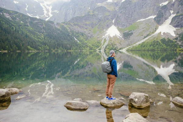 Adam gölde ve dağlarda dinleniyor. Güneşli manzara.