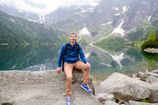 Adam gölde ve dağlarda dinleniyor. Güneşli manzara.