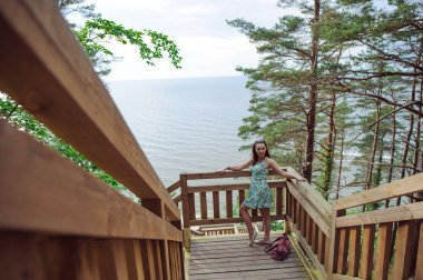 park ve gülümseyen ahşap merdivenlerde oturan kız