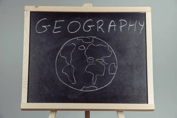 Geography lesson on blackboard or chalkboard. written in white chalk