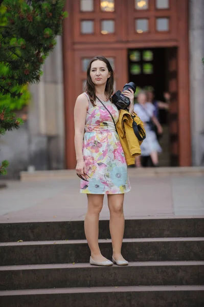 Mujer bastante joven divirtiéndose en la ciudad con la cámara de viaje foto del fotógrafo —  Fotos de Stock