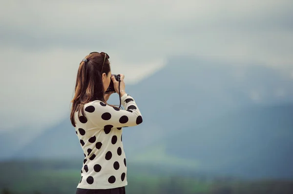 Mujer fotógrafa toma fotos en la montaña —  Fotos de Stock