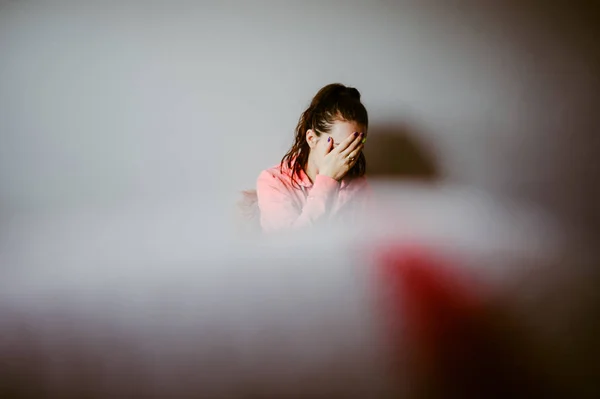 Frau sitzt mit genervten Sachen auf ihrem Bett und kratzt sich am Kopf — Stockfoto