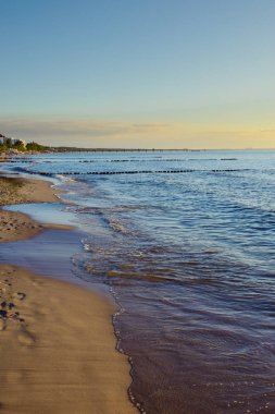 Günbatımı üzerinde Baltık Denizi'ndeki dalgakıranlar