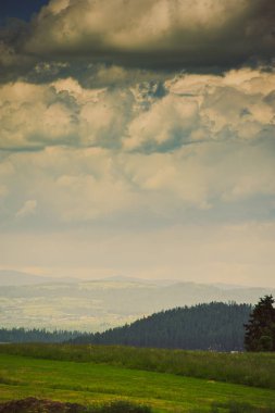 Mavi gökyüzünün altında yeşil çim kaplı tepeler