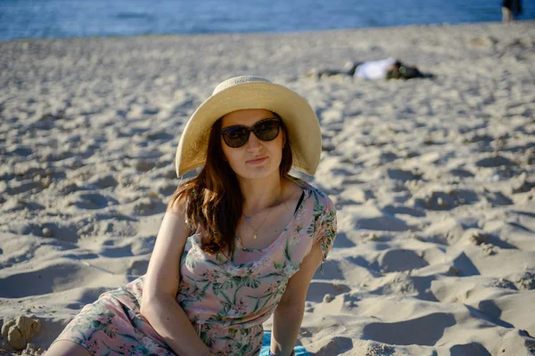 Porträt einer jungen Brünetten, die sich am Strand entspannt und ein Buch liest — Stockfoto