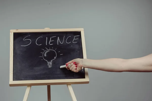 Un profesor escribiendo ciencia, dibujando elementos químicos en pizarra oscura a mano — Foto de Stock