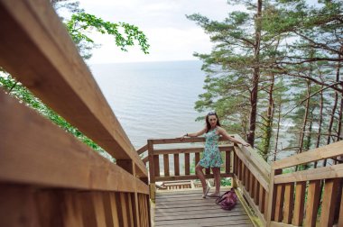 park ve gülümseyen ahşap merdivenlerde oturan kız