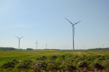 Parlak mavi gökyüzü hareket ediyor ve rüzgar türbini