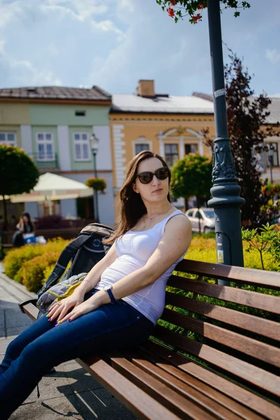 Frau sitzt auf Bank und blickt in Kamera — Stockfoto