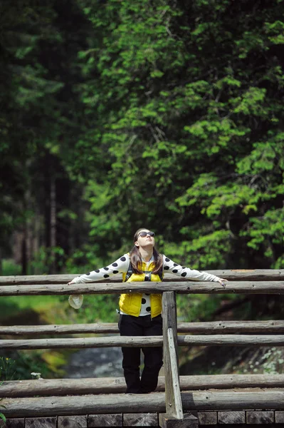 Mulher caminhando sobre ponte de madeira — Fotografia de Stock
