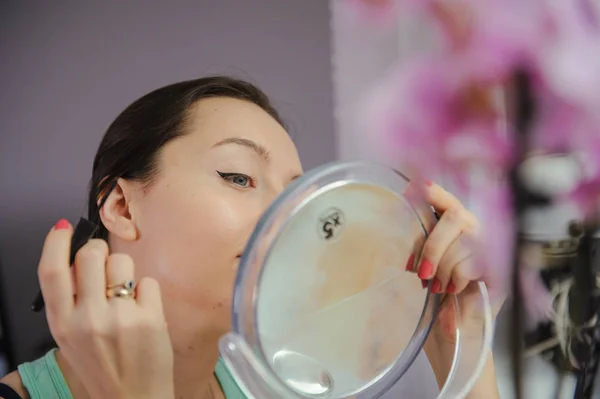 Mulher está fazendo maquiagem — Fotografia de Stock