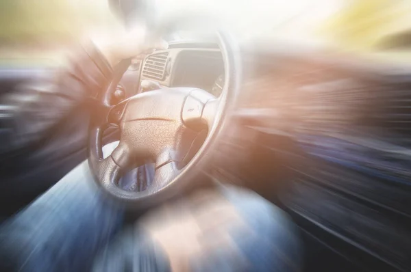 Hands on steering wheel of a car driving on an asphalt blurred road — Stock Photo, Image