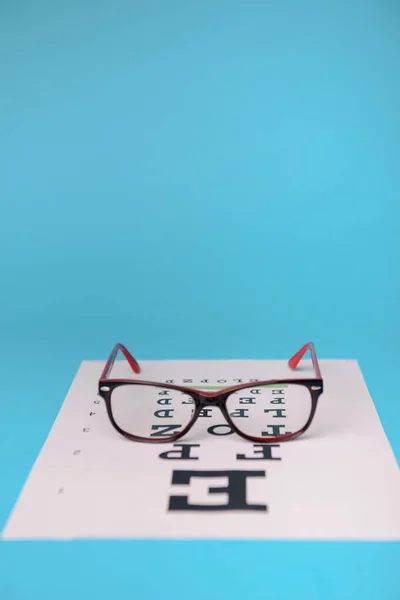 Glasses lying on snellen test chart — Stock Photo, Image