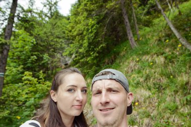 Arkadan aydınlatmalı dikey bir ormanda selfie fotoğraf çekici çift