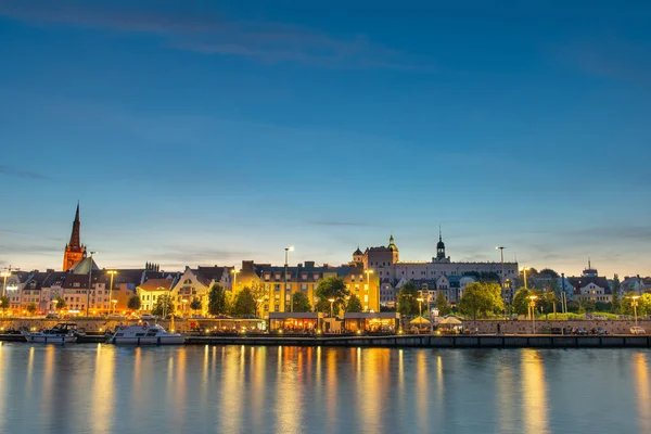 Szczecin. Vista noturna do outro lado do rio para o oi iluminado — Fotografia de Stock