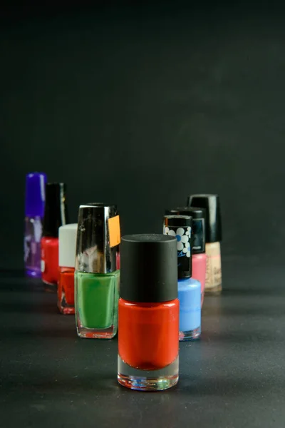 Цветной лак для ногтей бутылки на темном фоне — стоковое фото