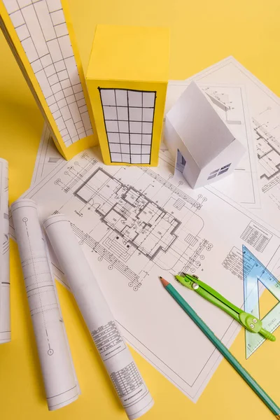 Fehér családi papír ház, ház projektek terv és tervrajzok sárga háttér papíron. Minimalista és egyszerű koncepció, stílus. Függőleges irány — Stock Fotó