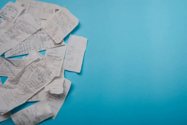 Pile of shopping receipts on blue background — Stock Photo, Image