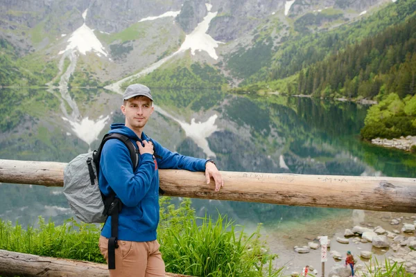 Muž relaxační na jezeře a hory slunné krajiny — Stock fotografie