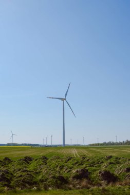 Parlak mavi gökyüzü hareket ediyor ve rüzgar türbini