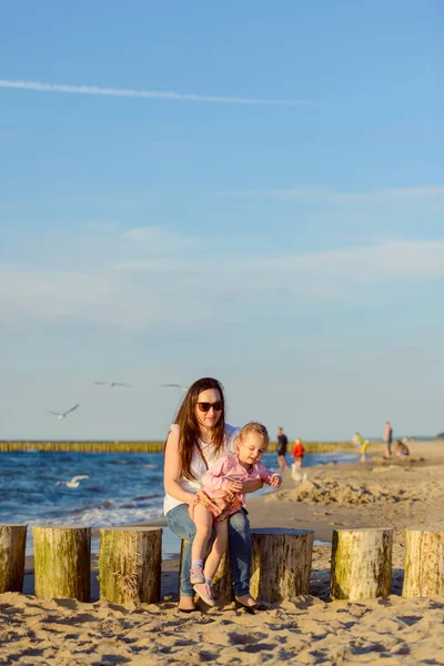 Moeder en dochtertje spelen op het strand. Authentiek beeld — Stockfoto