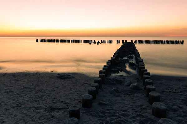 Dřevěná vlvoda při západu slunce v Baltském moři — Stock fotografie