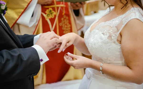 Bruden och brudgummen under bröllopsceremonin sätta vigselring — Stockfoto