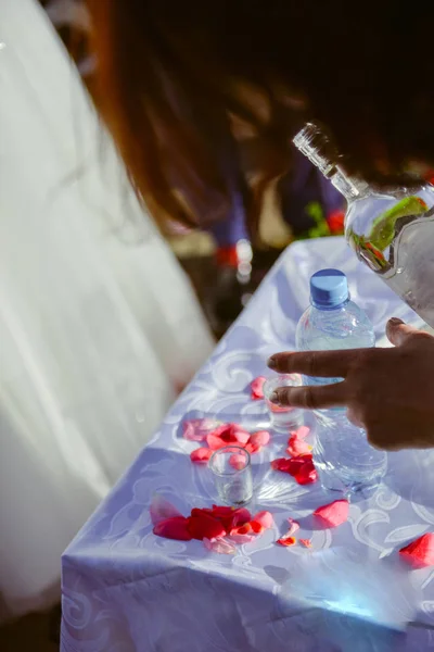 Bottle of cold vodka and wine bottle in bucket with ice and oran